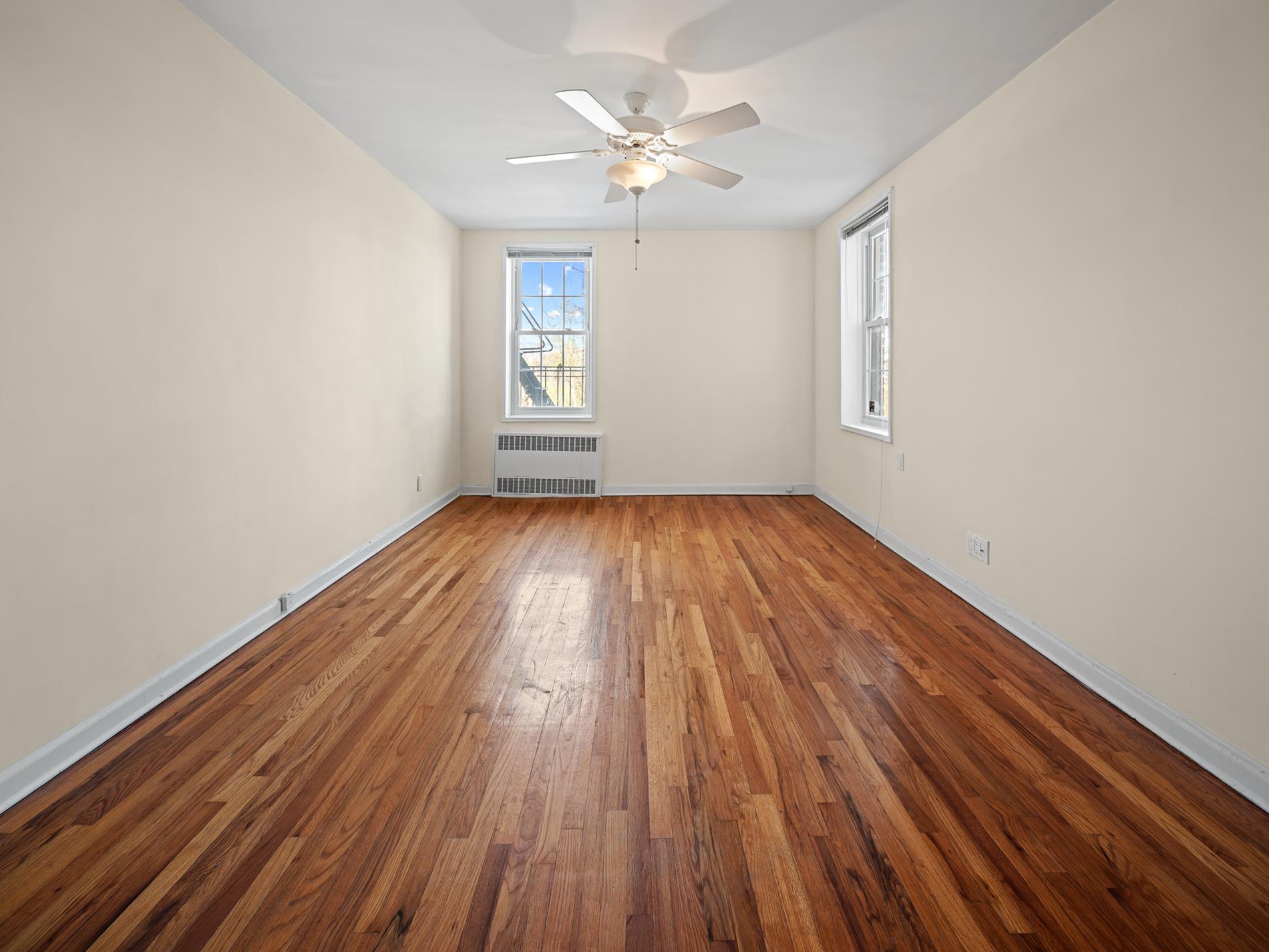 6665 Colonial Road, Unit 5D Brooklyn, NY 11220 - Photo 10 of 18 wooden floor in an empty room with a window