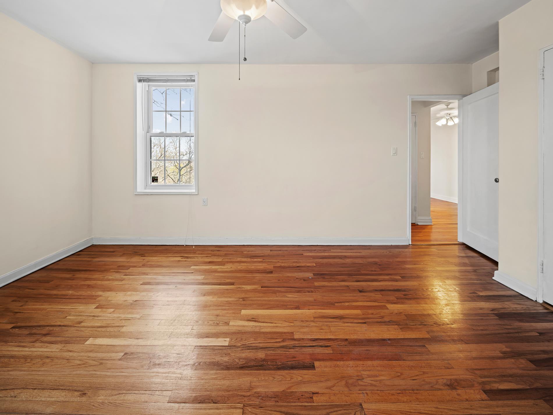 6665 Colonial Road, Unit 5D Brooklyn, NY 11220 - Photo 11 of 18 wooden floor in an empty room with a window