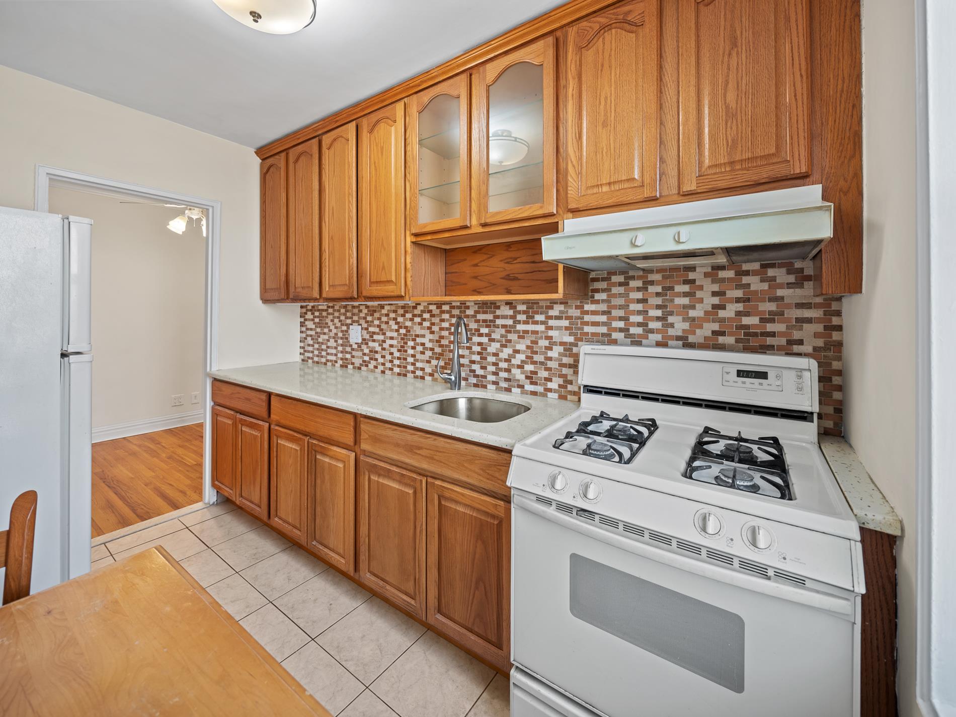 6665 Colonial Road, Unit 5D Brooklyn, NY 11220 - Photo 6 of 18 a kitchen with granite countertop cabinets and stove top oven