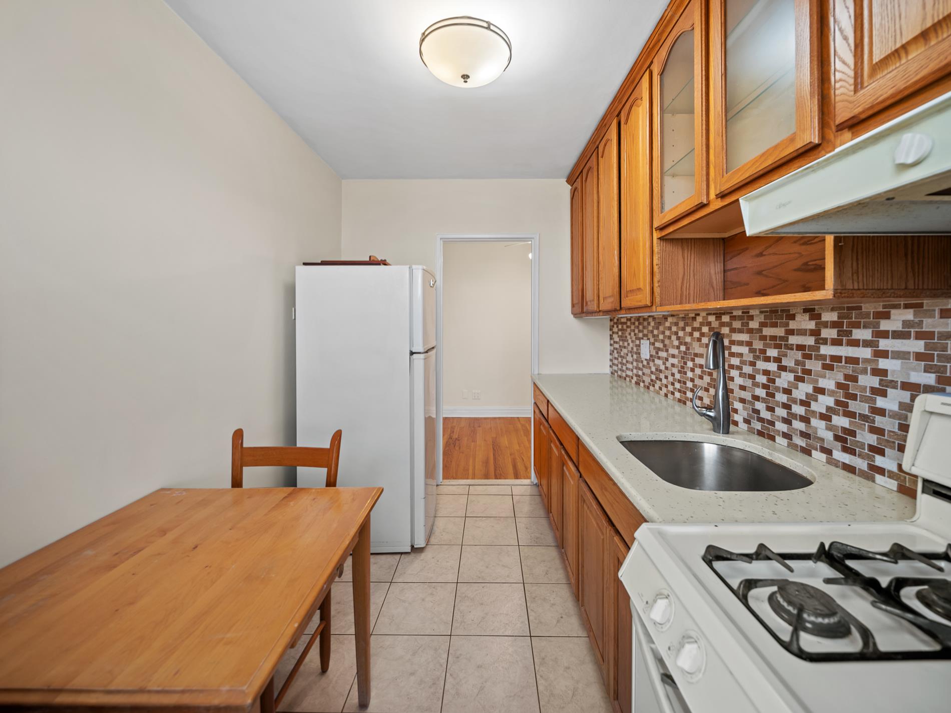 6665 Colonial Road, Unit 5D Brooklyn, NY 11220 - Photo 7 of 18 a kitchen with a sink and a stove top oven