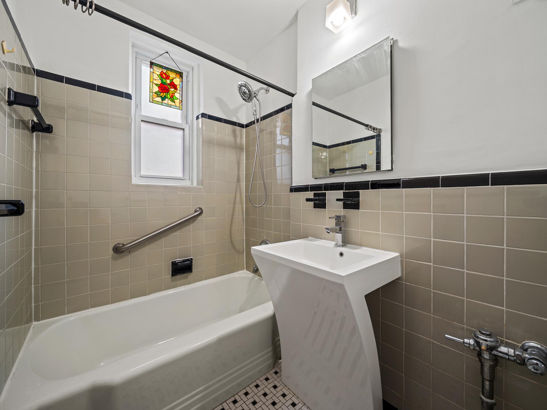 6665 Colonial Road, Unit 5D Brooklyn, NY 11220 - Photo 8 of 18 a bathroom with a sink a mirror and a shower