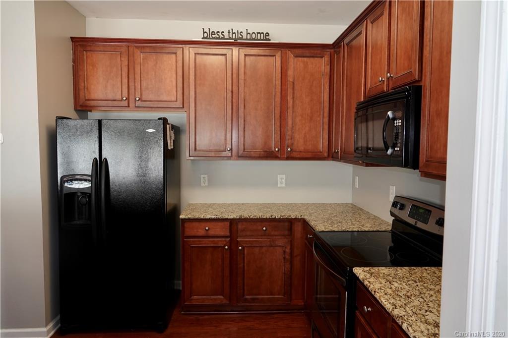 974 Copperstone Lane Fort Mill, SC 29708 - Photo 9 of 22 a kitchen with granite countertop a refrigerator stove and cabinets