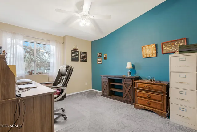 a view of a workspace with furniture and a window