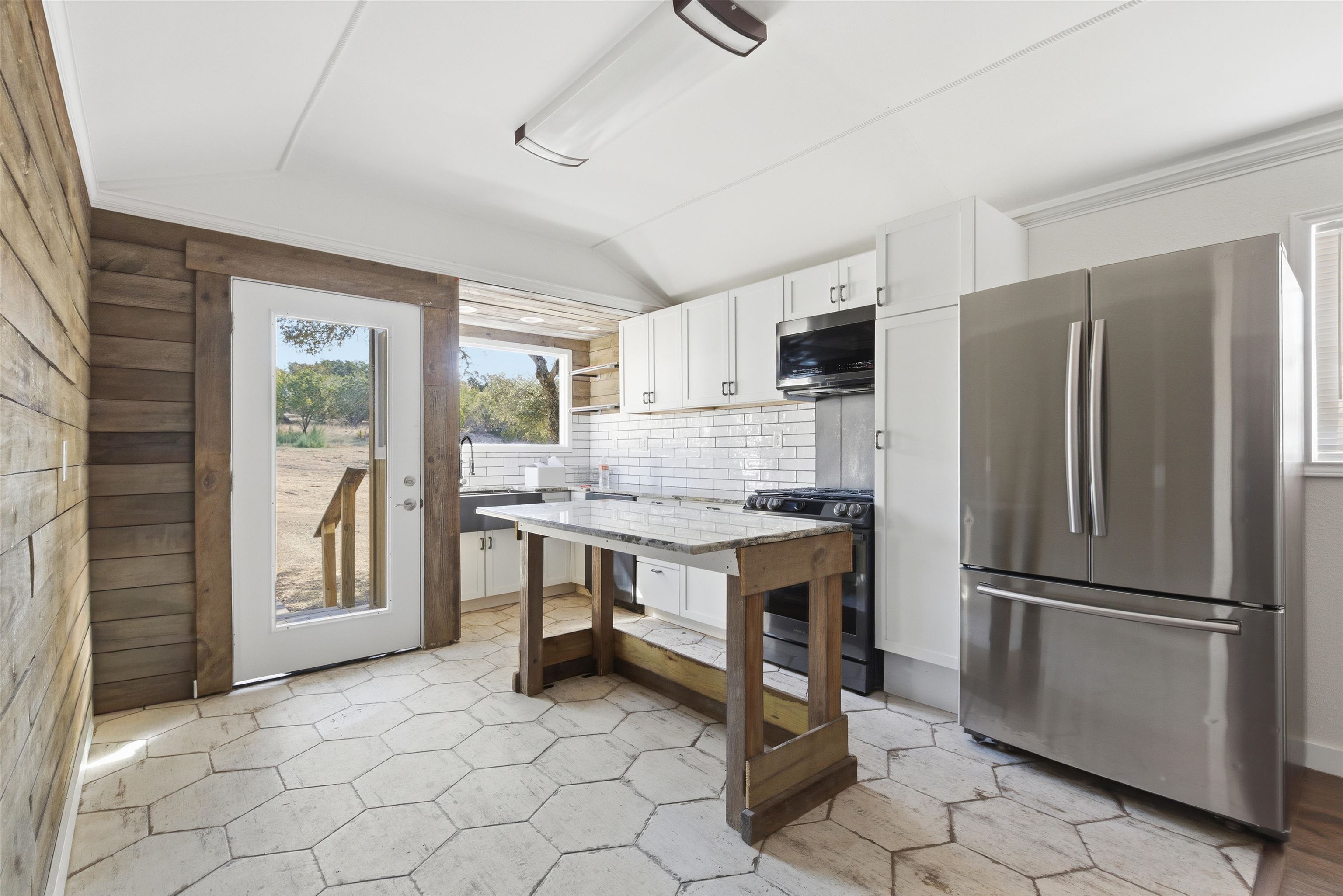 418 Polvado Round Mountain, TX 78663 - Photo 11 of 26 a kitchen with stainless steel appliances granite countertop a refrigerator stove and sink