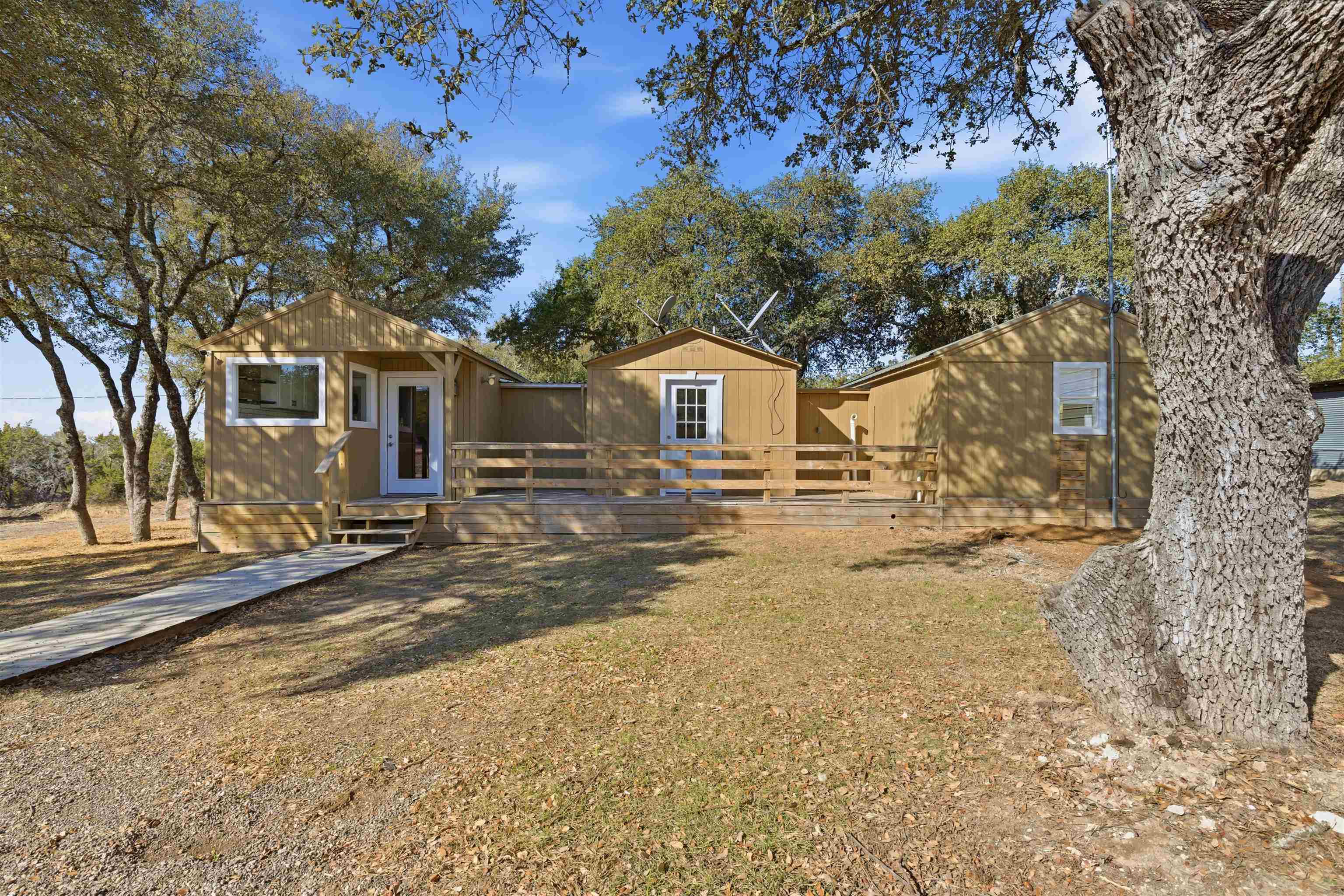418 Polvado Round Mountain, TX 78663 - Photo 2 of 26 a view of a white house with a large tree