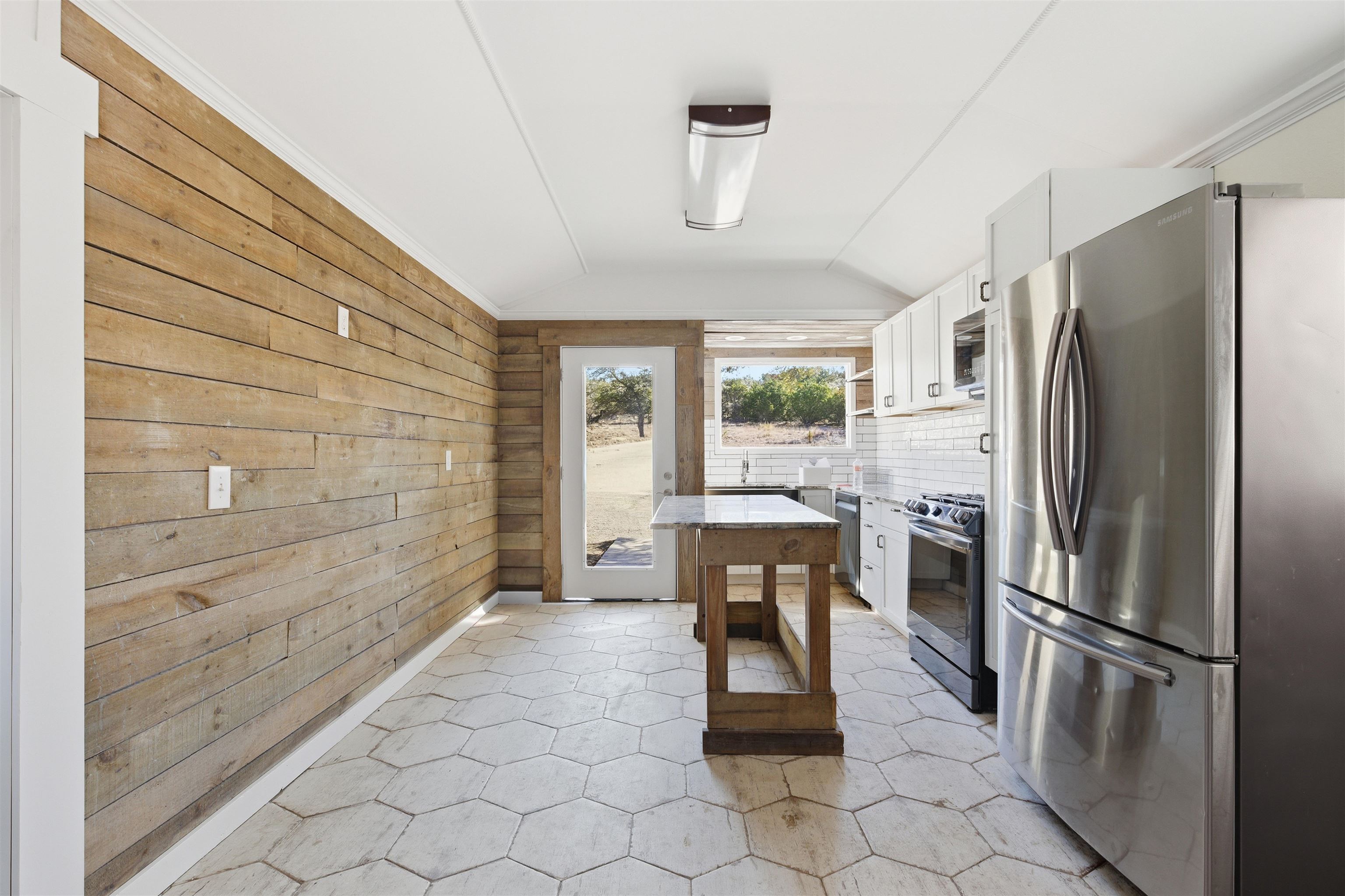418 Polvado Round Mountain, TX 78663 - Photo 10 of 26 a kitchen with stainless steel appliances a refrigerator and wooden cabinets