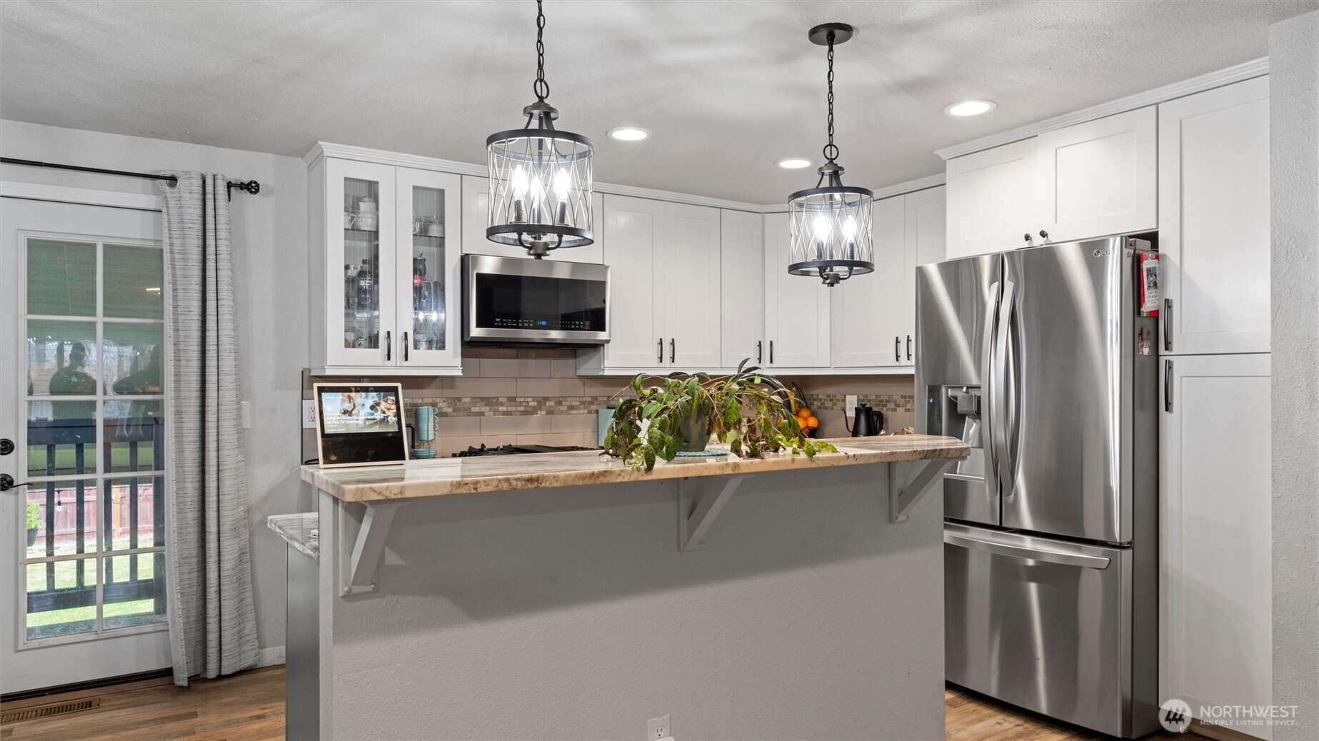 321 South Sheppard Street Kennewick, WA 99336 - Photo 7 of 22 a kitchen with stainless steel appliances granite countertop a refrigerator a sink dishwasher a refrigerator and a dining table with wooden floor