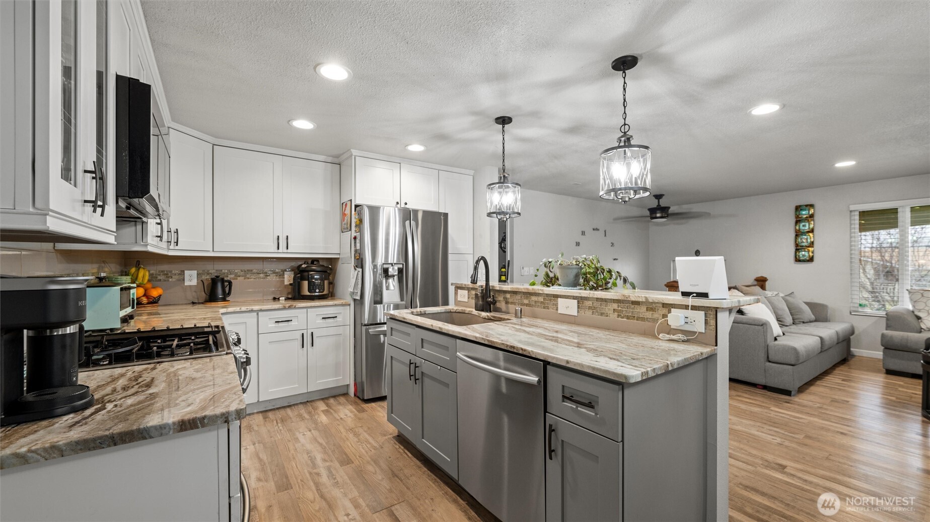 321 South Sheppard Street Kennewick, WA 99336 - Photo 9 of 22 a kitchen with center island white cabinets and refrigerator