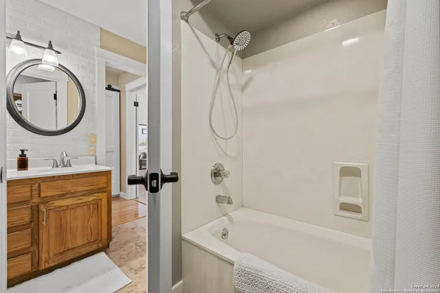 a bathroom with a tub a sink and a mirror