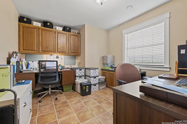a work place with table chairs and a window