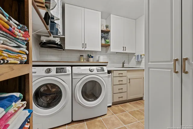 a utility room with sink dryer and washer