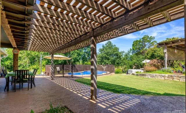 a view of a patio with table and chairs potted plants and palm trees
