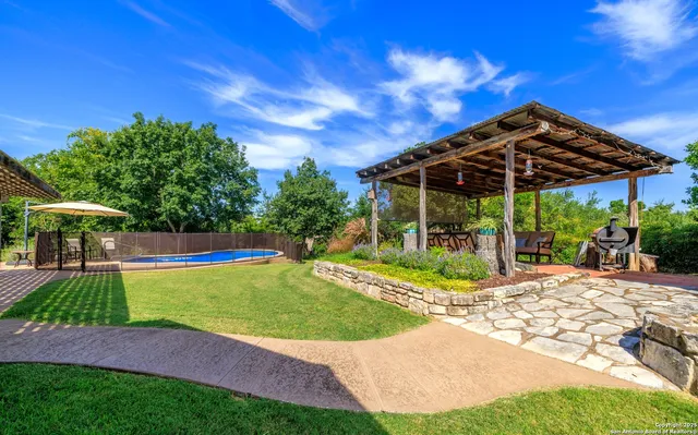 a view of a backyard with a garden and swimming pool