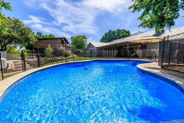 a view of swimming pool with seating area and green space