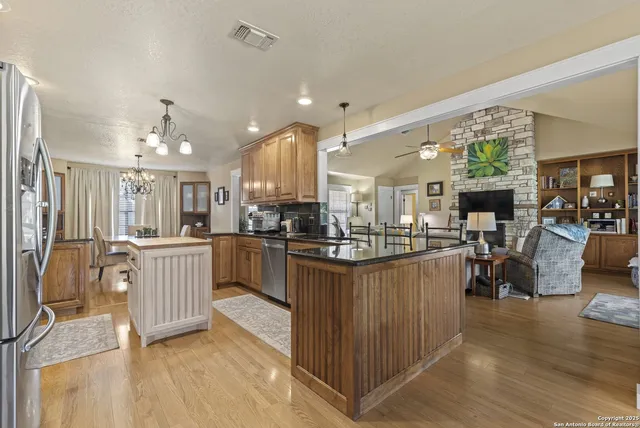 a kitchen with kitchen island granite countertop lots of counter top space and stainless steel appliances