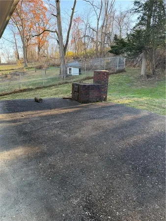 an empty room with wooden floor and fan