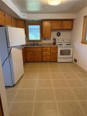 a kitchen with a cabinets a stove a sink and a refrigerator