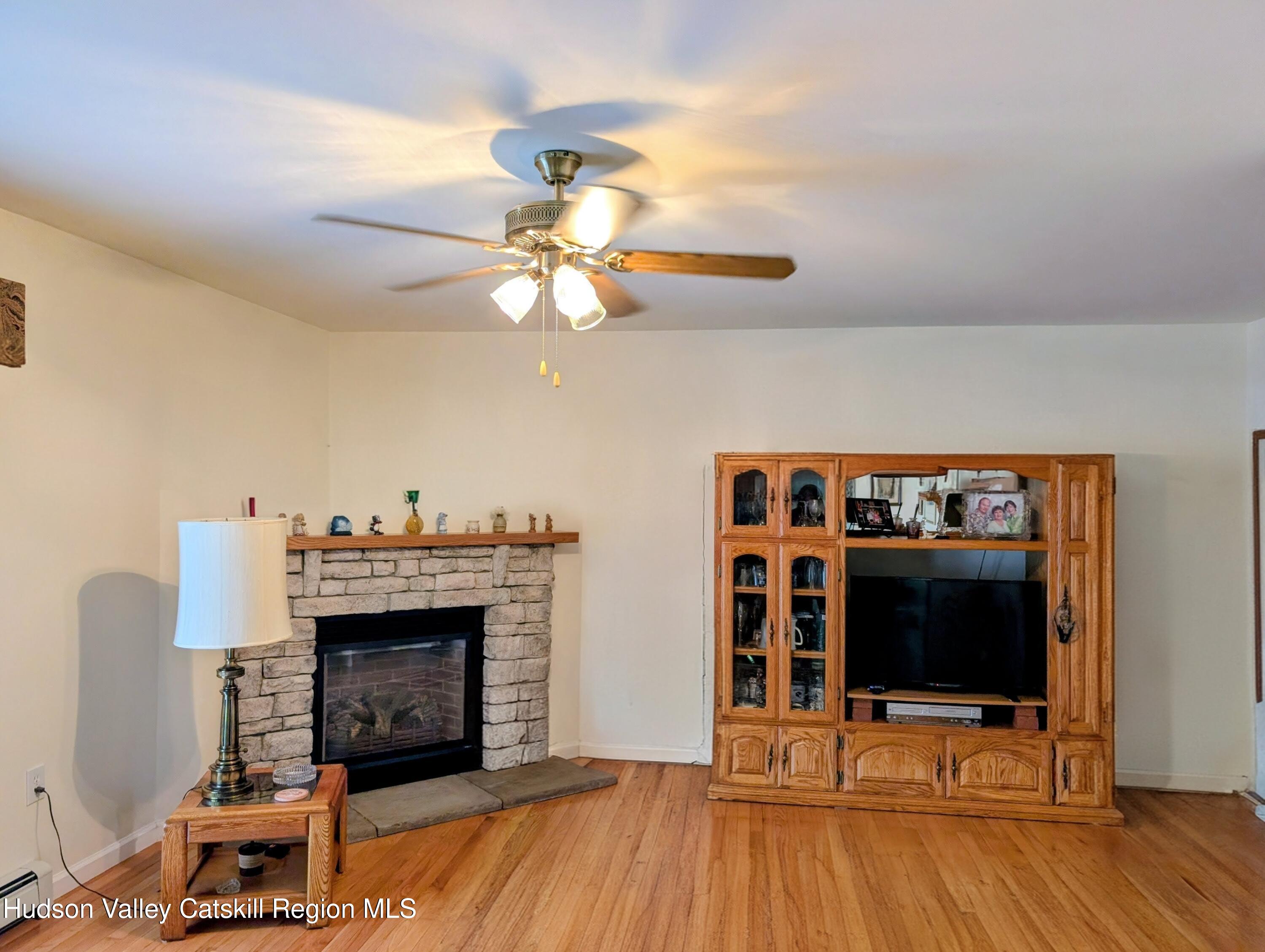 834 Co Rte 19 Elizaville, NY 12523 - Photo 4 of 32 a living room with furniture a flat screen tv and a fireplace