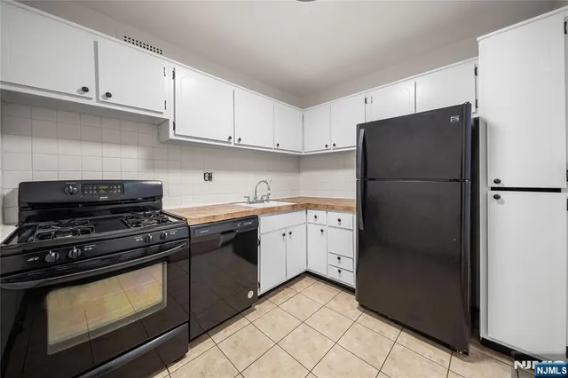 a kitchen with a sink cabinets and a stove top oven