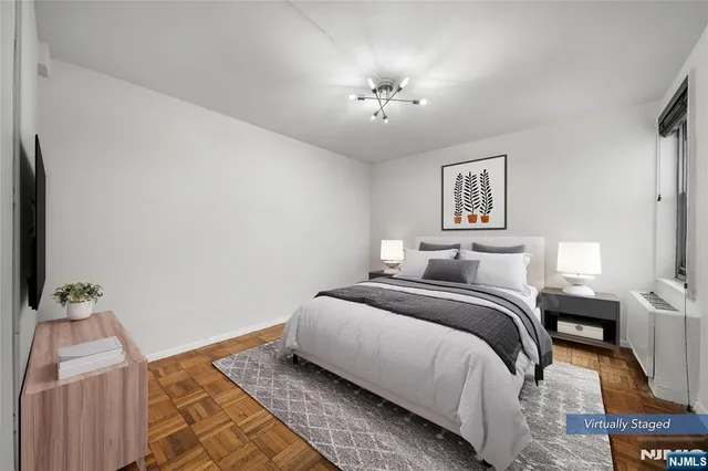 an empty room with a chandelier fan and wooden floor