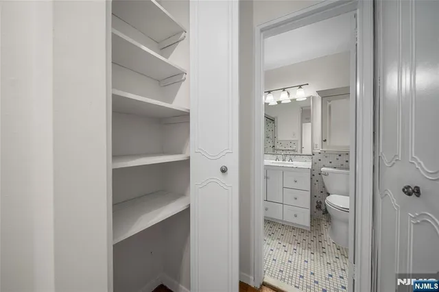 a bathroom with a sink a toilet a mirror a vanity and bathtub