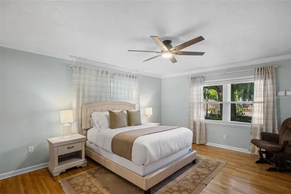 a bedroom with a bed and a large window with chair