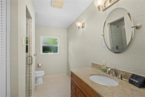 a bathroom with a granite countertop sink a toilet and a mirror