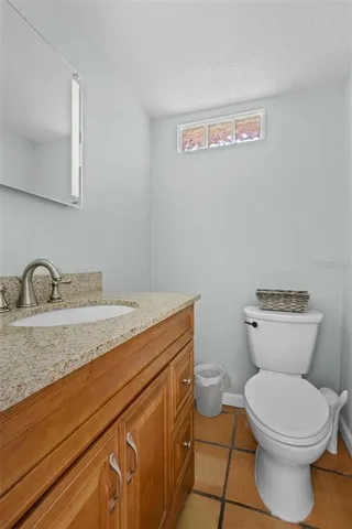 a bathroom with a granite countertop toilet and a sink