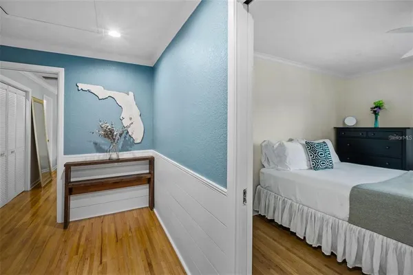 a bedroom with bed and wooden floor