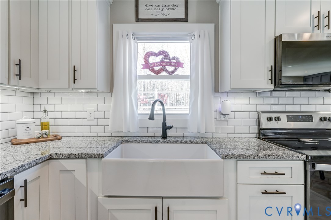 20903 Matoaca Road Petersburg, VA 23803 - Photo 6 of 42 a kitchen with granite countertop a sink stainless steel appliances and cabinets