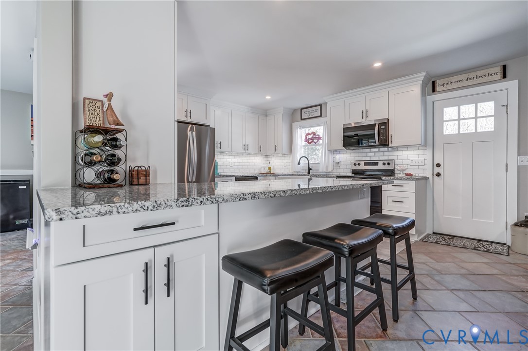 20903 Matoaca Road Petersburg, VA 23803 - Photo 10 of 42 a kitchen with stainless steel appliances kitchen island granite countertop a sink and cabinets