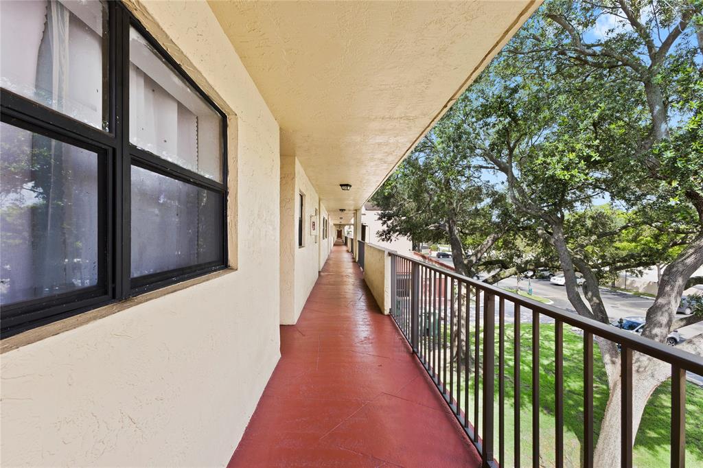 3199 Foxcroft Road, Unit 304 Miramar, FL 33025 - Photo 2 of 23 a view of a balcony with wooden floor and fence