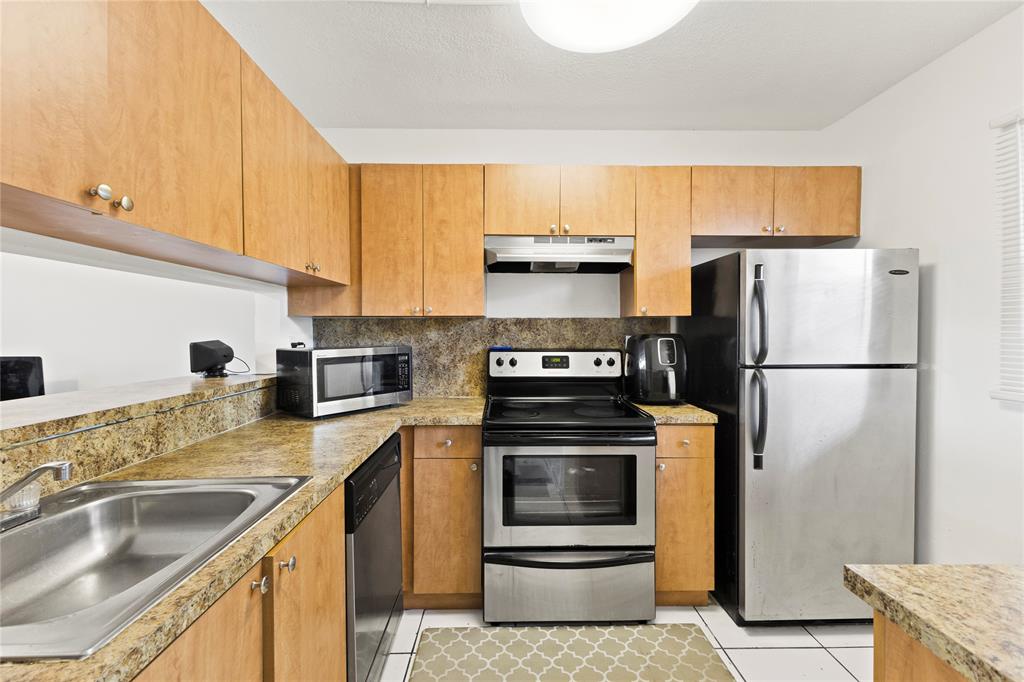 3199 Foxcroft Road, Unit 304 Miramar, FL 33025 - Photo 4 of 23 a kitchen with a refrigerator sink and stove