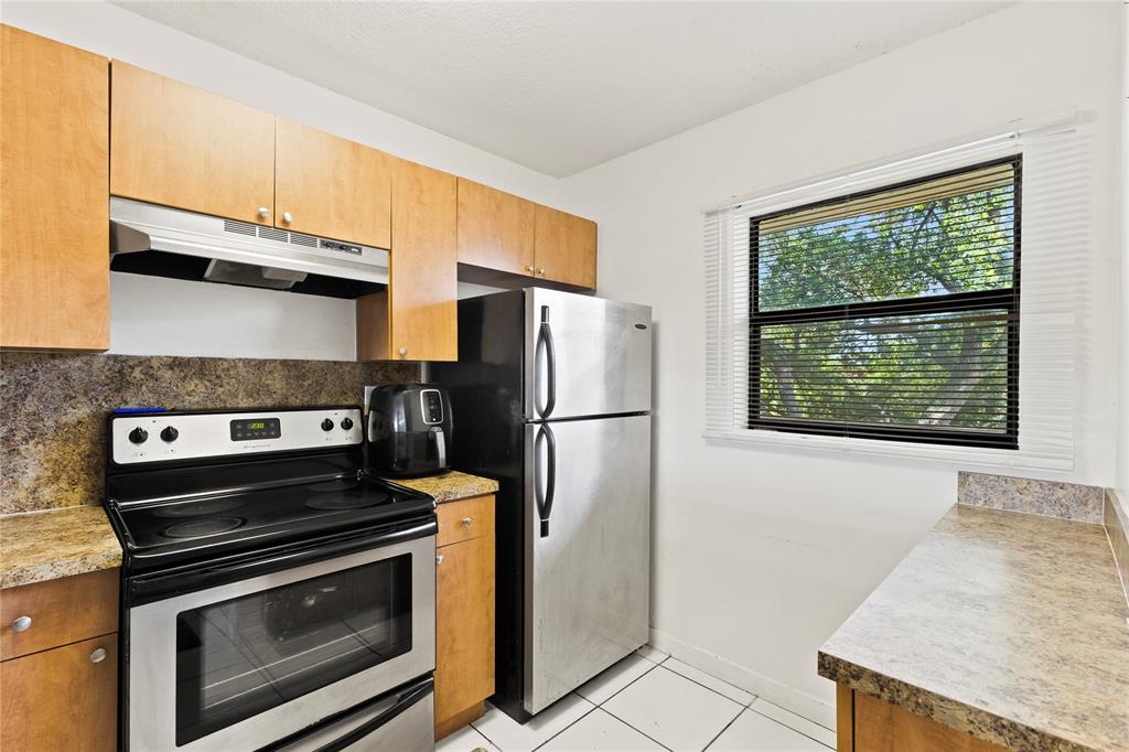 3199 Foxcroft Road, Unit 304 Miramar, FL 33025 - Photo 6 of 23 a kitchen with a stove a fridge and a window