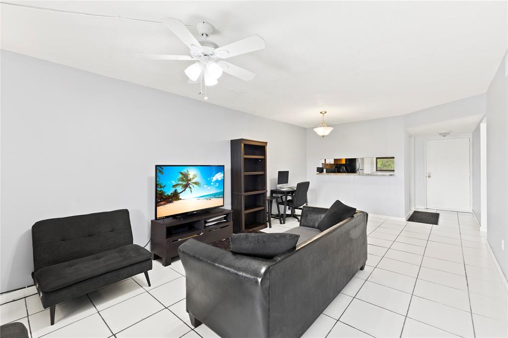 3199 Foxcroft Road, Unit 304 Miramar, FL 33025 - Photo 9 of 23 a living room with furniture and a flat screen tv