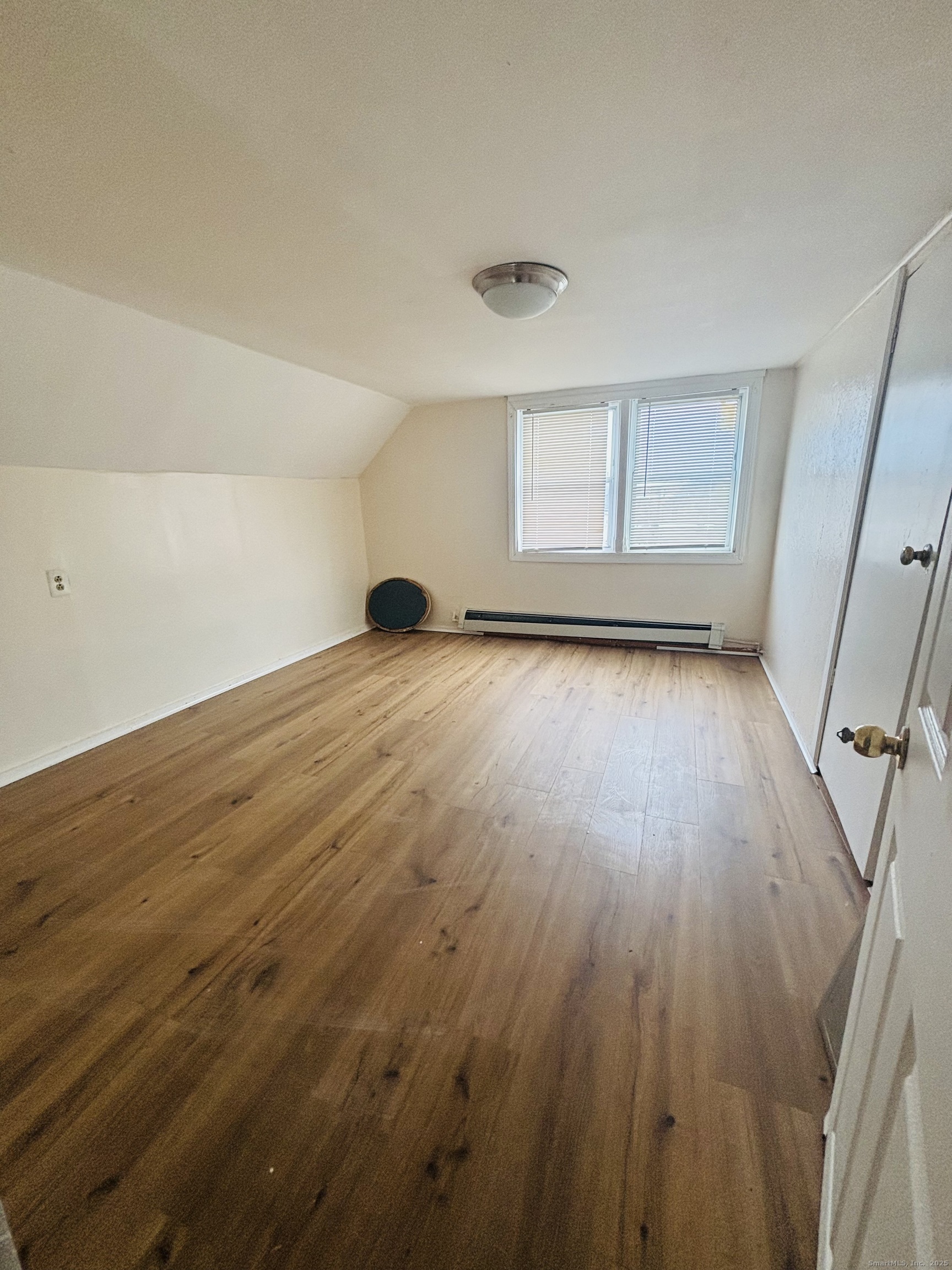 259 6th Street Bridgeport, CT 06607 - Photo 3 of 4 an empty room with wooden floor and windows