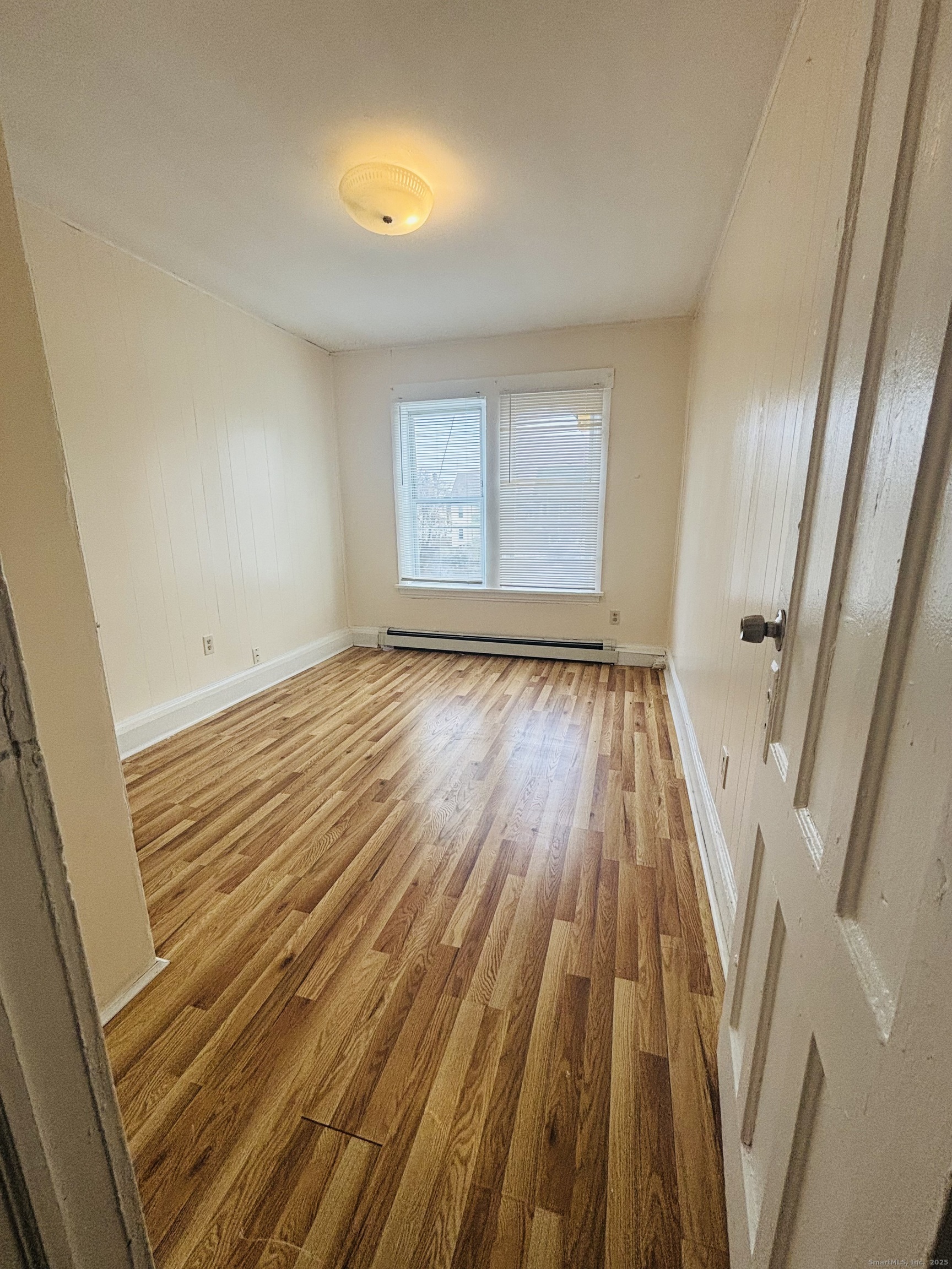 259 6th Street Bridgeport, CT 06607 - Photo 4 of 4 a view of an empty room with wooden floor and a window
