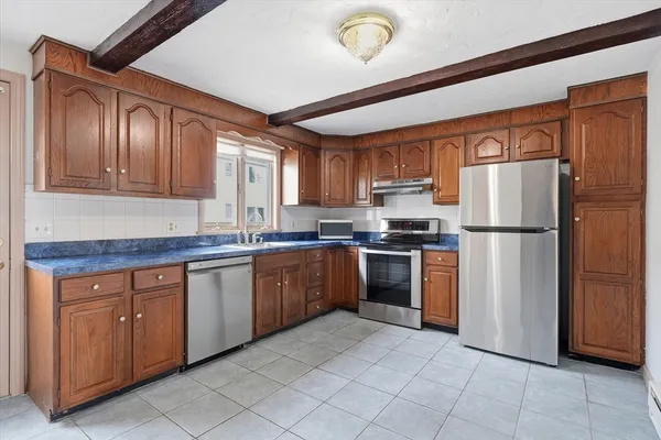 a kitchen with granite countertop stainless steel appliances a refrigerator and a sink
