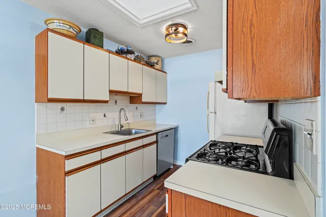 a kitchen with a sink a stove and cabinets