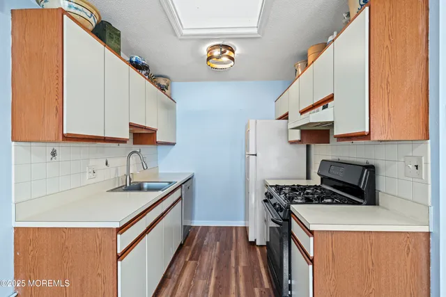 a kitchen with a sink a stove and cabinets