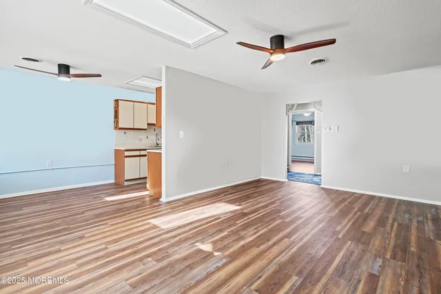 a view of empty room with wooden floor