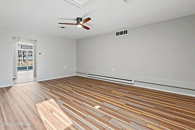 a view of a room with wooden floor and white walls