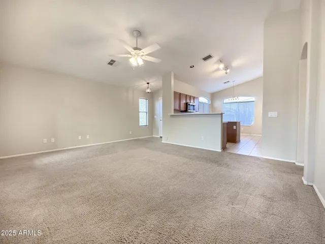 a view of a kitchen with chandelier fan and windows
