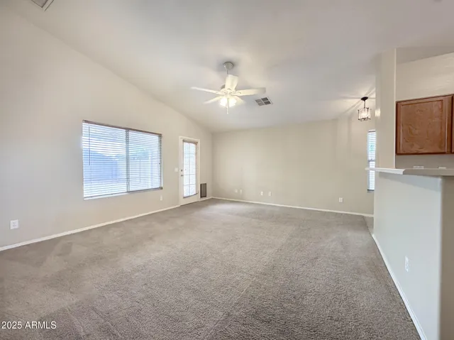 a view of a room with chandelier fan and windows