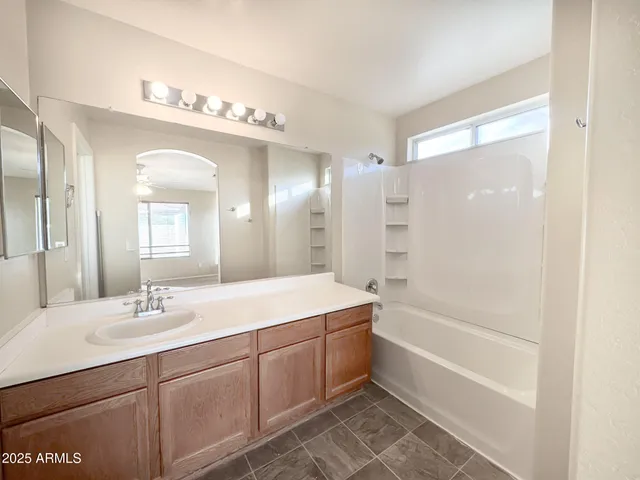 a bathroom with a tub sink double vanity and a mirror
