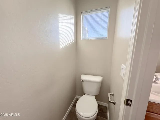 a white toilet sitting next to a white cabinet