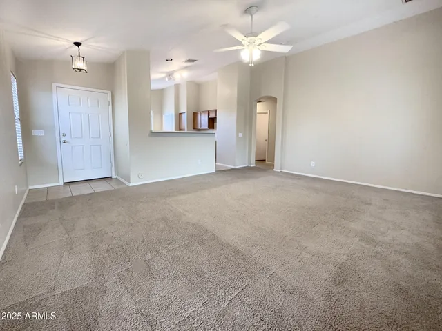 an empty room with fan and entrance
