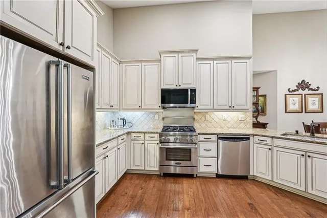 a kitchen with stainless steel appliances a refrigerator sink and cabinets
