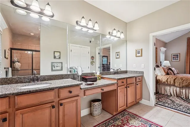 a spacious bathroom with a granite countertop double vanity sink a mirror and shower