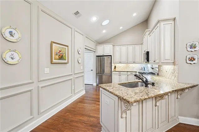 a kitchen with stainless steel appliances granite countertop a sink stove and refrigerator